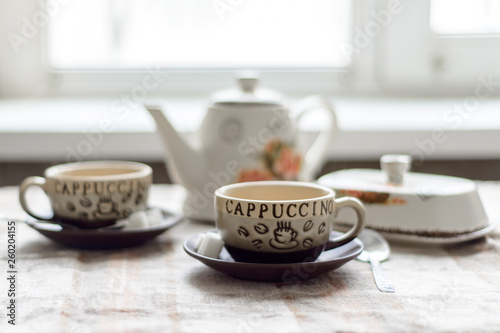 Wallpaper Mural brewer, grease cup and two cups with a hot drink on saucers with sugar cubes on the breakfast table Torontodigital.ca