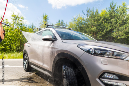 Manual car wash with pressurized water.