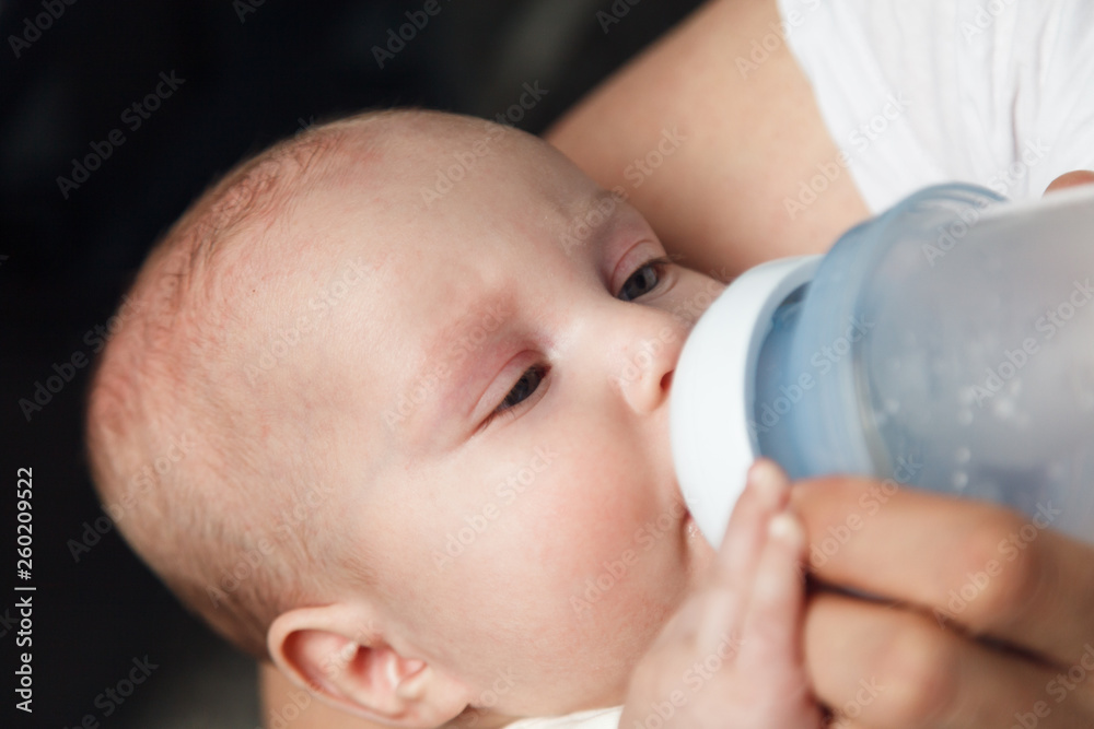 Baby drinking milk from bottle holding by father. Healthy nutrition Baby drinking milk from bottle holding by father. Healthy nutrition