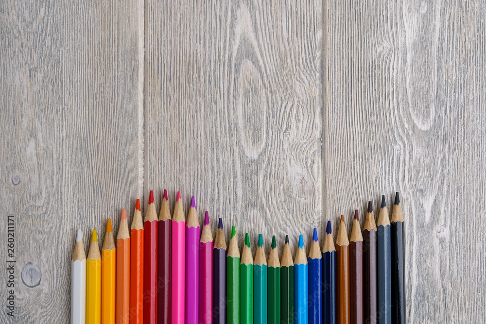 collection of rainbow spectrum color crayons on a white-grey vintage table with copy space