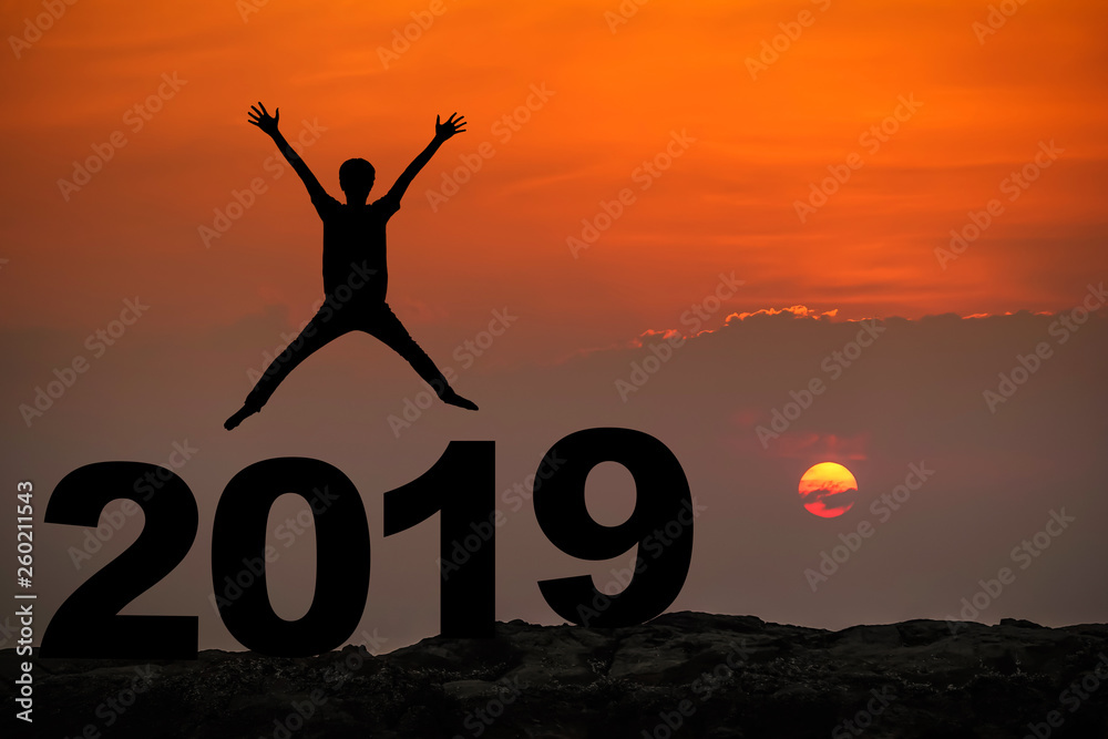 Silhouette of young man happy jumping and hand up between 2019 new year, sky and sun light background. copy space for text. Future and time passing concept. Silhouette of young man happy jumping and hand up between 2019 new year, sky and sun light background. copy space for text. Future and time passing concept.