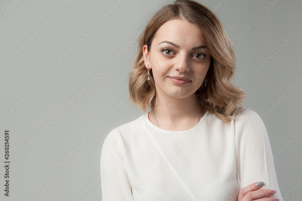 Portrait of a young attractive woman with blond hair on a neutral gray background. Portrait of a young attractive woman with blond hair on a neutral gray background.