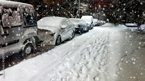 Low angle view of cars parked along a street at night in winter. Panoramic © Shcherbyna