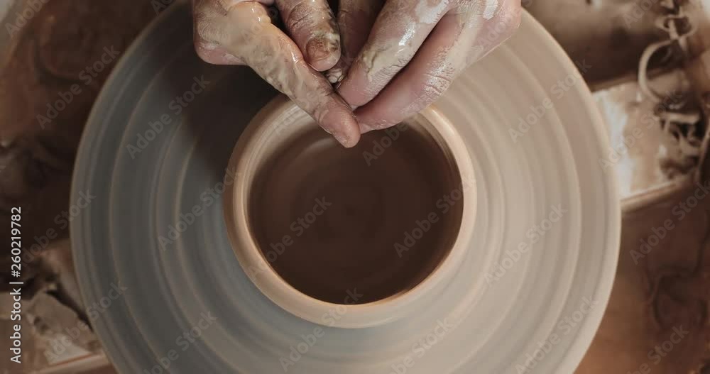 Potter making ceramic pot on the twisted pottery wheel. Top view. Potter at work, close up. Handmade, craft. White clay Potter making ceramic pot on the twisted pottery wheel. Top view. Potter at work, close up. Handmade, craft. White clay