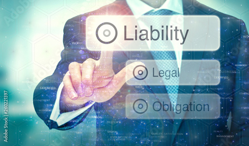 A business man selecting a button on a futuristic display with a Liability concept written on it.