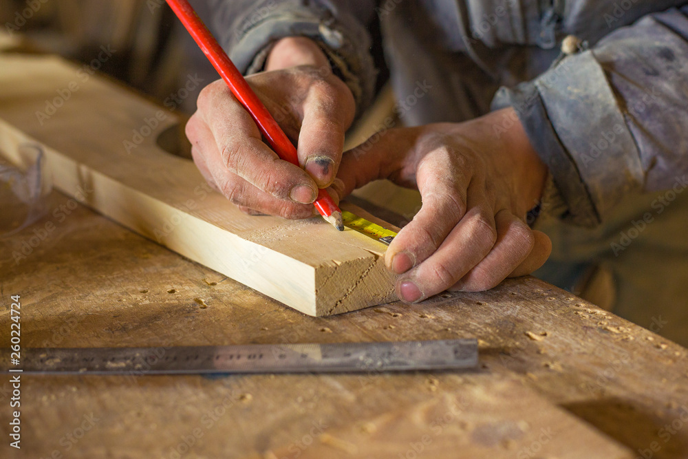 measuring with a centimeter and a pencil by a carpenter in a woodworking workshop measuring with a centimeter and a pencil by a carpenter in a woodworking workshop