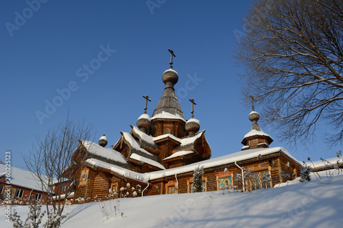 Wooden church in sunny winter day. Christian temple of the Holy Martyr John the Warrior in Novokuznetsk, Russia. photo