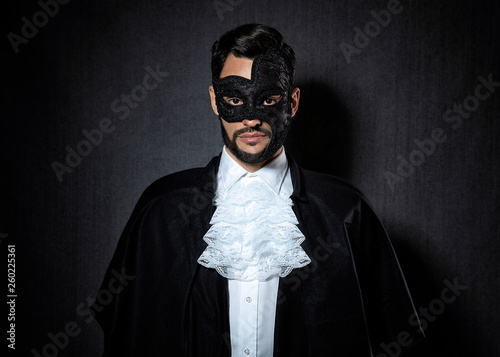Young man wearing a dark mask, dressed in a Phantom of the Opera look