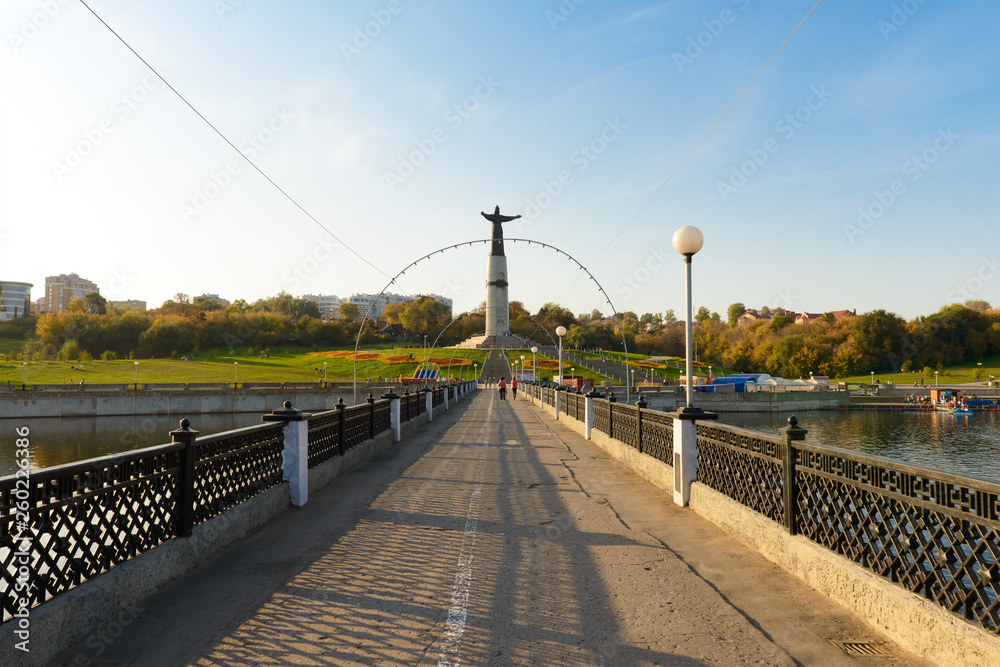 August 26, 2015: Embankment of the Cheboksary Bay with a pedestrian bridge and the statue of the Patron Mother. Cheboksary. Russia.