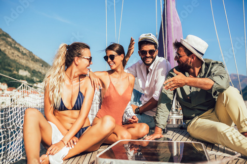 Smiling friends sitting on sailboat deck and having fun.Vacation, travel, sea, friendship and people concept © Mediteraneo