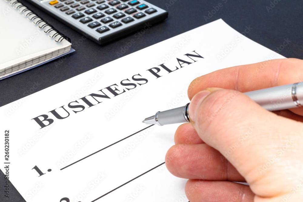 Strategy business plan with pen, calculator and notebook on dark table. Strategy business plan with pen, calculator and notebook on dark table.