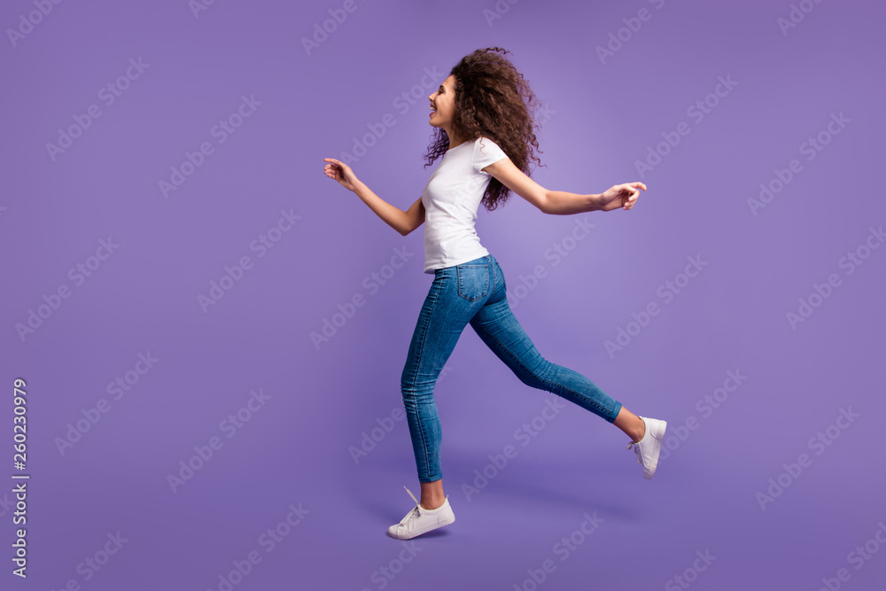 Full length side profile body size photo funky beautiful amazing she her lady jump high hands arms shopping store mall wear casual jeans denim white t-shirt sneakers isolated purple violet background