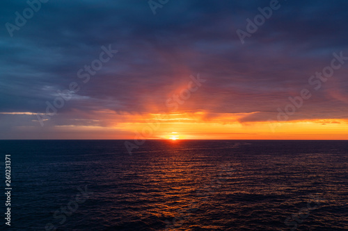 Cloudy sunrise view over the ocean horizon.