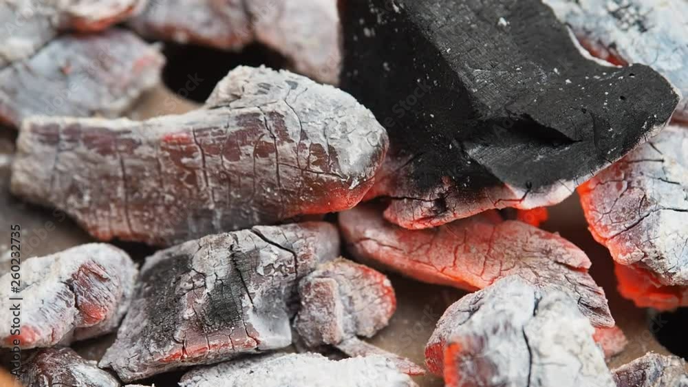 Close up hot charcoal and firewood burning in a grill. There is flame and heat. Close up hot charcoal and firewood burning in a grill. There is flame and heat.