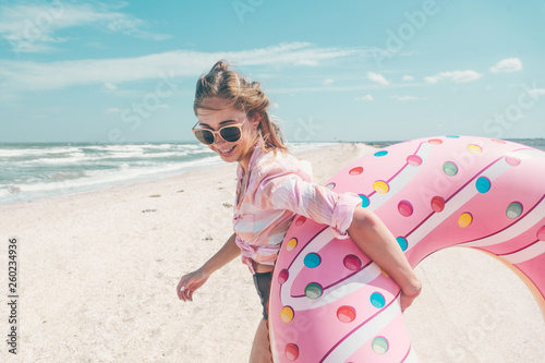 Girl relaxing on donut lilo on the beach