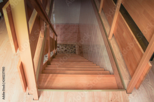 Top view of a new wooden staircase with railing lit by a window