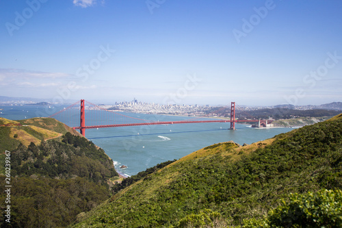 Golden Gate Bridge shot from a high point. Strait of the Golden Gate. Sunny weather and green vegetation.