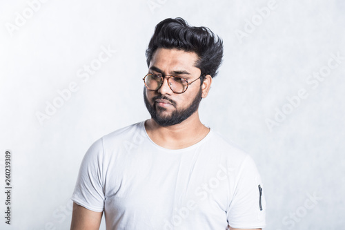 Portrait of a handsome young stylish man with beard and glasses.