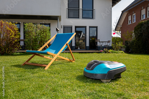 Mähroboter neben Liegestuhl im Garten