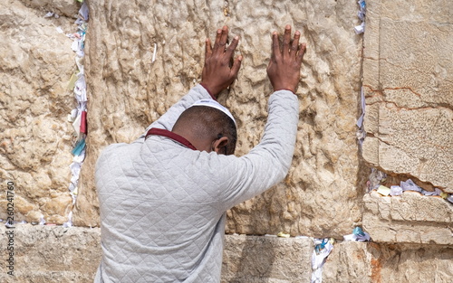 Undefined afro-american young man pray at the Western Wall. Jerusalem. Israel photo