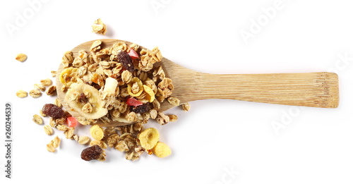 Crunchy tropical muesli pile mix with banana, pineapple, papaya slices and raisins with wooden spoon isolated on white background © dule964