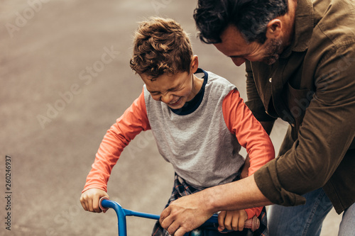 Fototapeta Naklejka Na Ścianę i Meble -  Kid having fun learning to ride bicycle