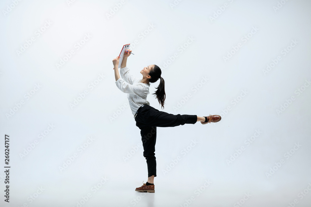 Don't be afraid to set goals. Happy woman working at office, jumping and dancing in casual clothes or suit isolated on white studio background. Business, start-up, working open-space concept.