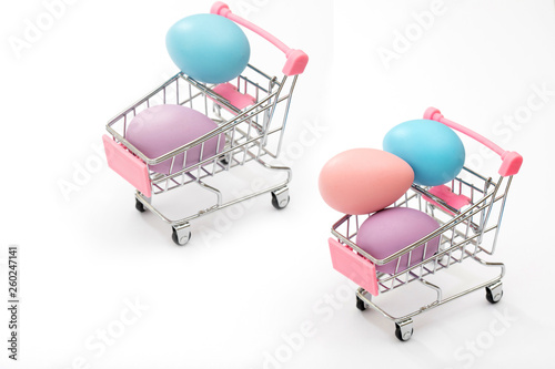 Colorful Easter Eggs in a shopping car on a seamless white background. photo