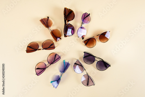 Stylish sunglasses in sun shape on yellow background. summer is coming concept.