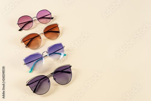 Different sunglasses on yellow background. Frame. Summer banner. Copy space.