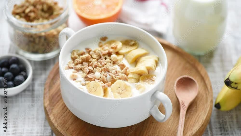Bowl of granola with milk and fresh fruits on a wooden table. Healthy eating, healthy lifestyle concept. HD footage Bowl of granola with milk and fresh fruits on a wooden table. Healthy eating, healthy lifestyle concept. HD footage