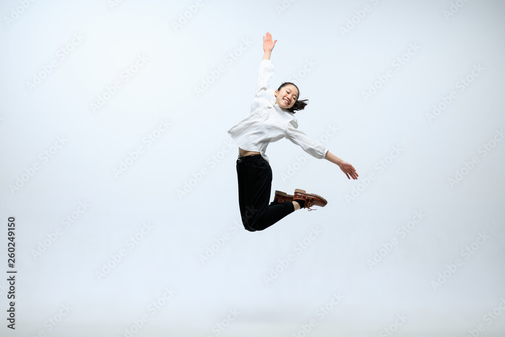 The begining of the new life. Happy woman working at office, jumping and dancing in casual clothes or suit isolated on white studio background. Business, start-up, working open-space concept.
