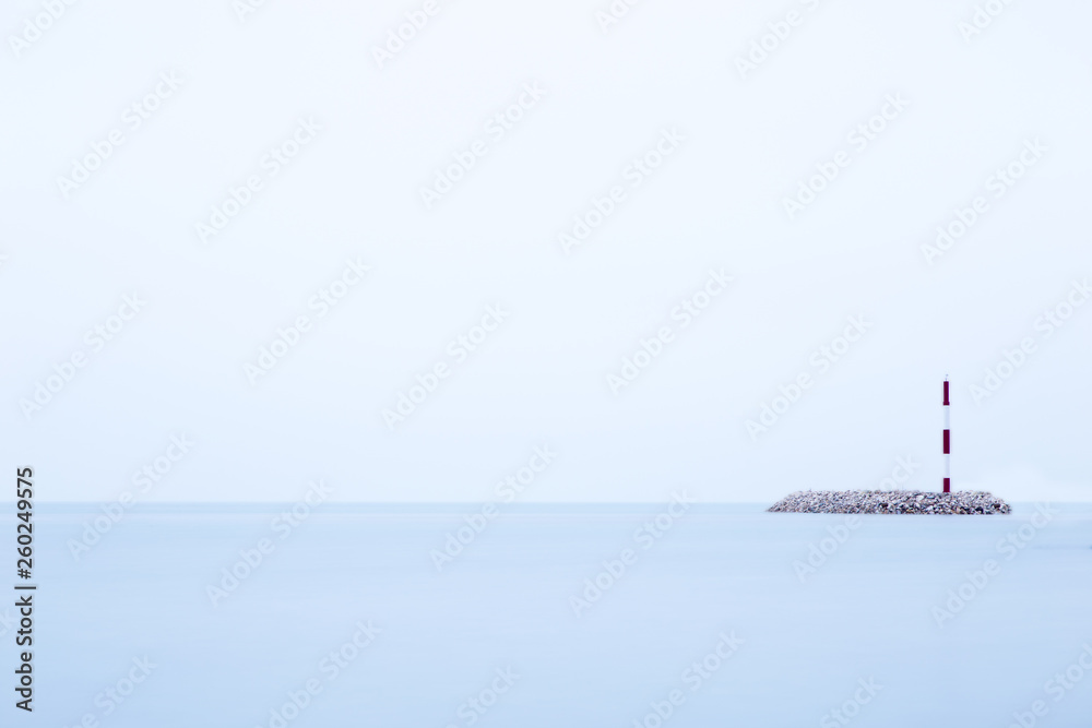 Fototapeta premium Leuchtturm einsam im wasser auf einer insel