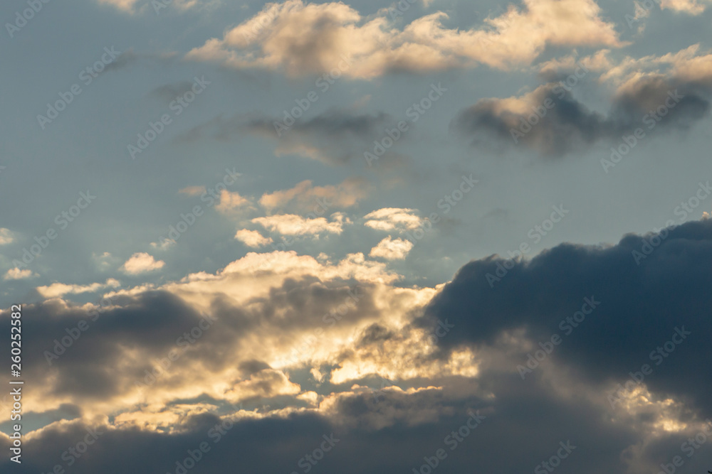 Blue sky at sunset with colorful clouds. Blue, yellow, white, gray and dark blue. Beautiful nature concept for design