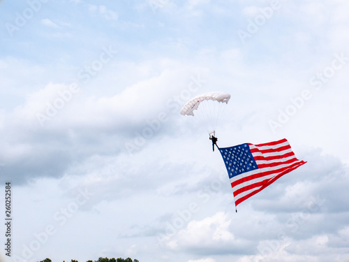 presentation of colors by skydiver carrying huge american flag at sporting event in the united states of amaerica photo