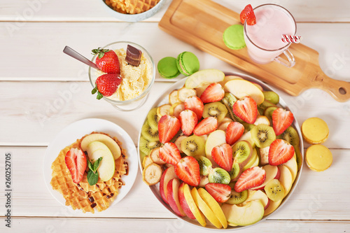 Vegetarian sliced ​​fruit. Strawberries, kiwi, bananas, apples are sliced. Raw food and healthy food.