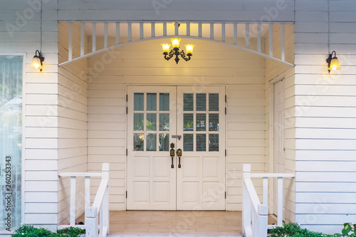 Typical front of vintage small white wooden house with vintage lamp