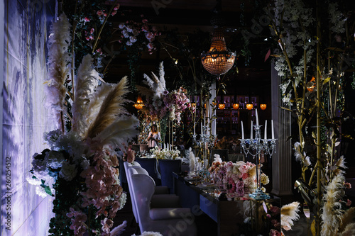 a wedding hall decorated with flowers and a chic chandelier hanging from the ceiling