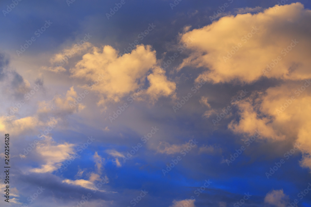 evening blue sky with golden sunset clouds as a natural background