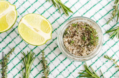 Homemade herbal scrub (foot soak or bath salt) with rosemary, thyme, lime juice, sea salt and olive oil. DIY beauty treatments and spa recipe. Top view, copy space 