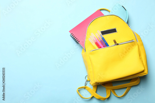 yellow backpack with different school supplies