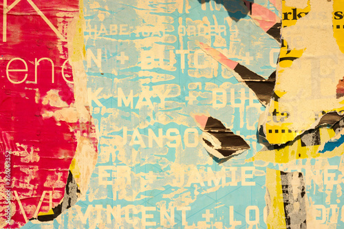 Fotografie Old grunge ripped torn vintage collage colorful street posters creased crumpled