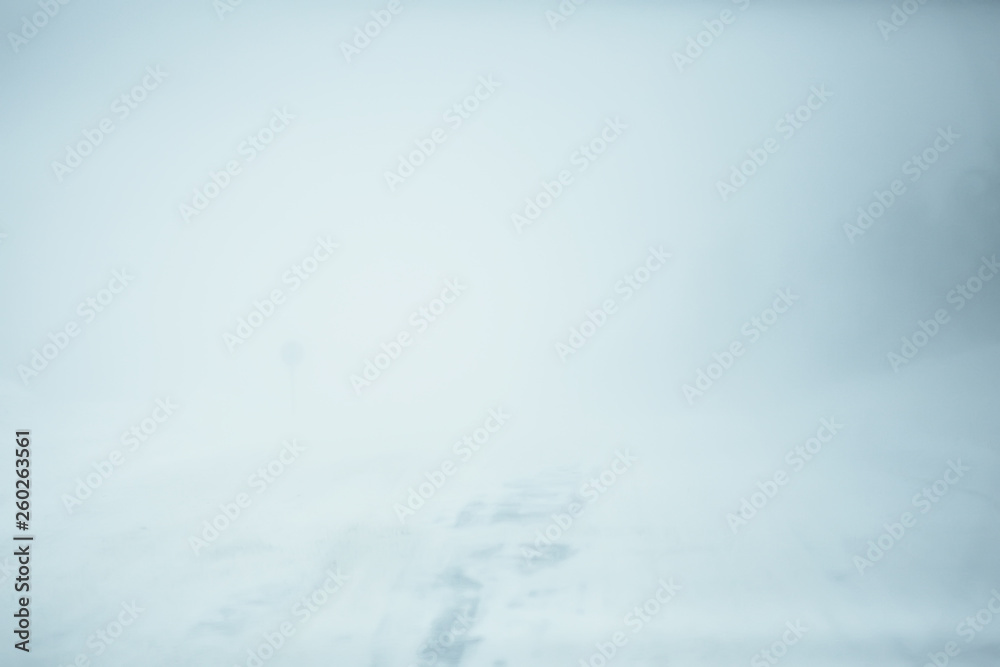 Obraz premium snow and fog on the winter road landscape / view of the seasonal weather a dangerous road, a winter lonely landscape