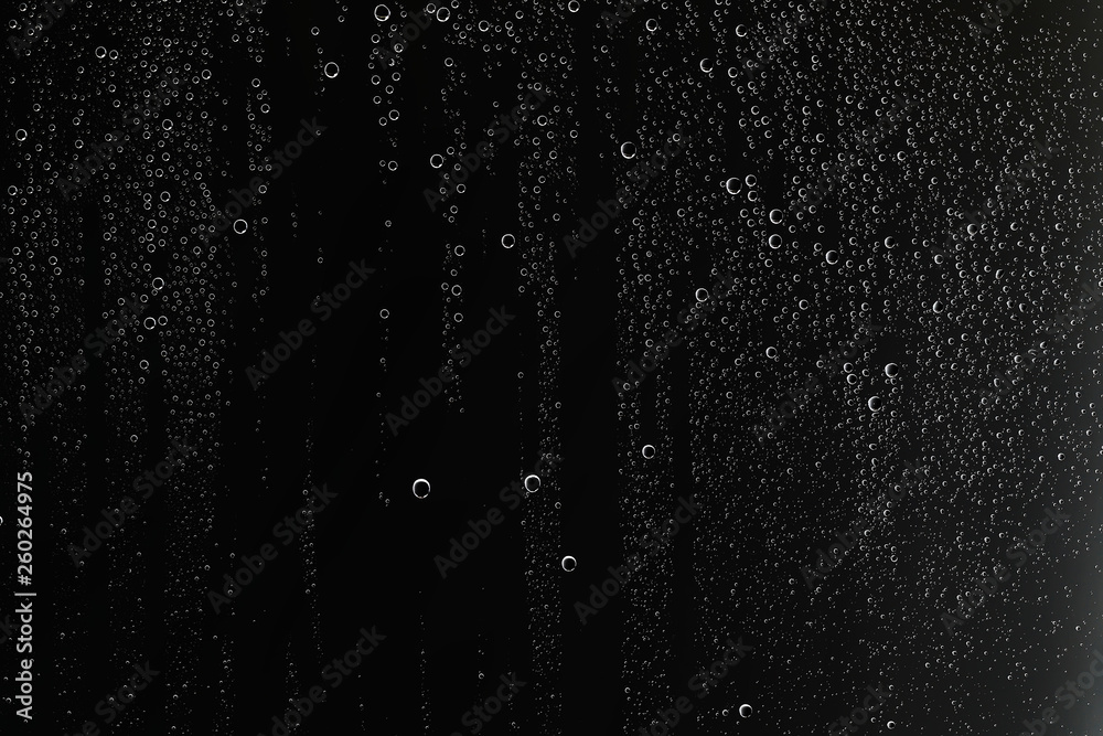 Obraz premium black wet background / raindrops for overlaying on window, concept of autumn weather, background of drops of water rain on glass transparent