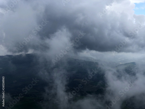 Foggy mountains, green hills and villages, clouds in the sky