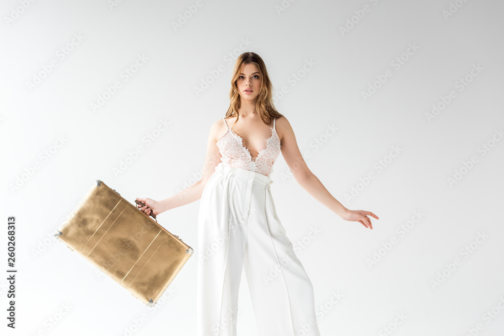 beautiful woman holding travel bag while standing on white beautiful woman holding travel bag while standing on white