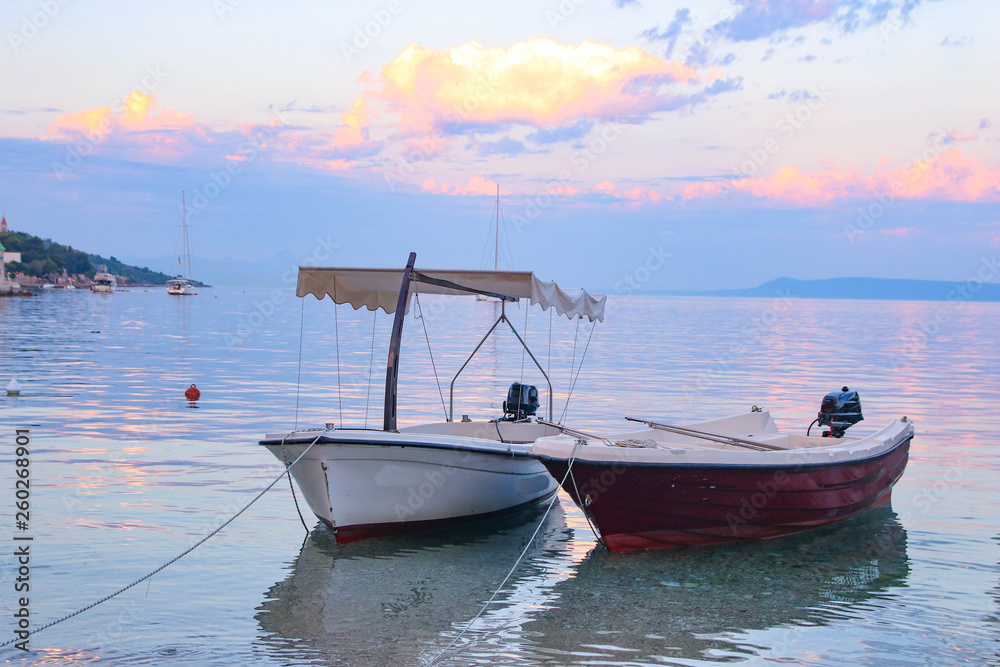 Beautiful sunset landscape. Fishing boats moored on Brac coast in Dalmatia,Croatia. Old town near Adriatic sea.