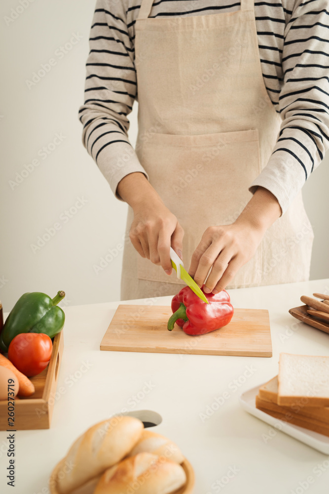 Male hands slicing fresh red bell peppers