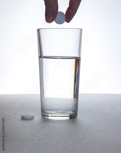 clear glass and pills on white table