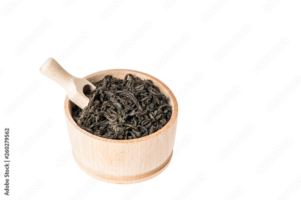 Close up, macro. Wooden bowl with large leaf dried black tea. Isolated on white background. Inside placed measuring spoon. Close up, macro. Wooden bowl with large leaf dried black tea. Isolated on white background. Inside placed measuring spoon.